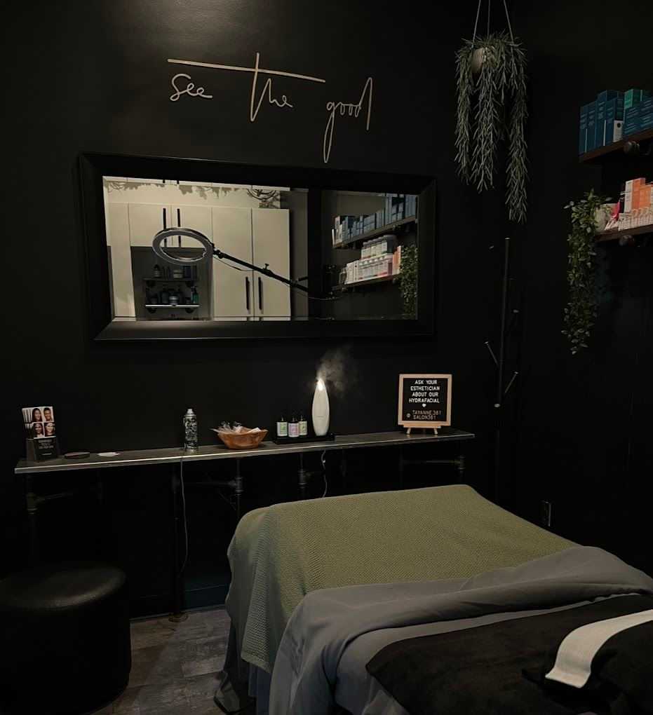 A cozy, dimly lit spa room with a treatment table and calming decor.