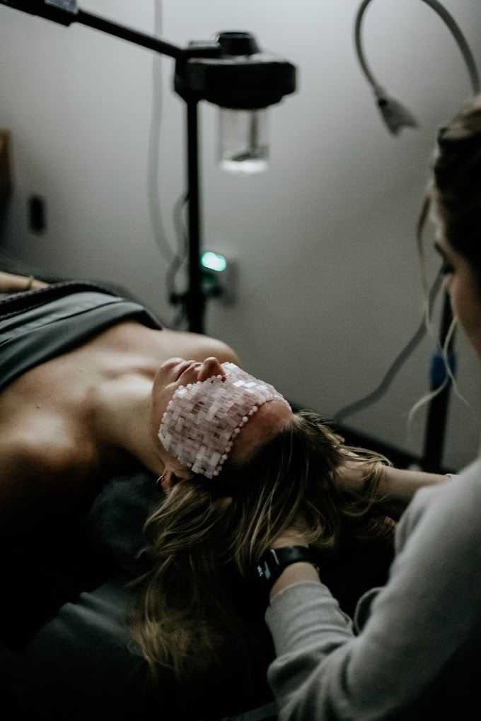 Facial treatment with LED light therapy and eye protection.