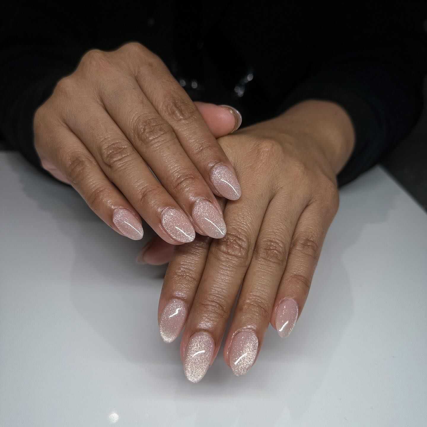 Elegant nude nails with subtle glitter and intricate white line designs.